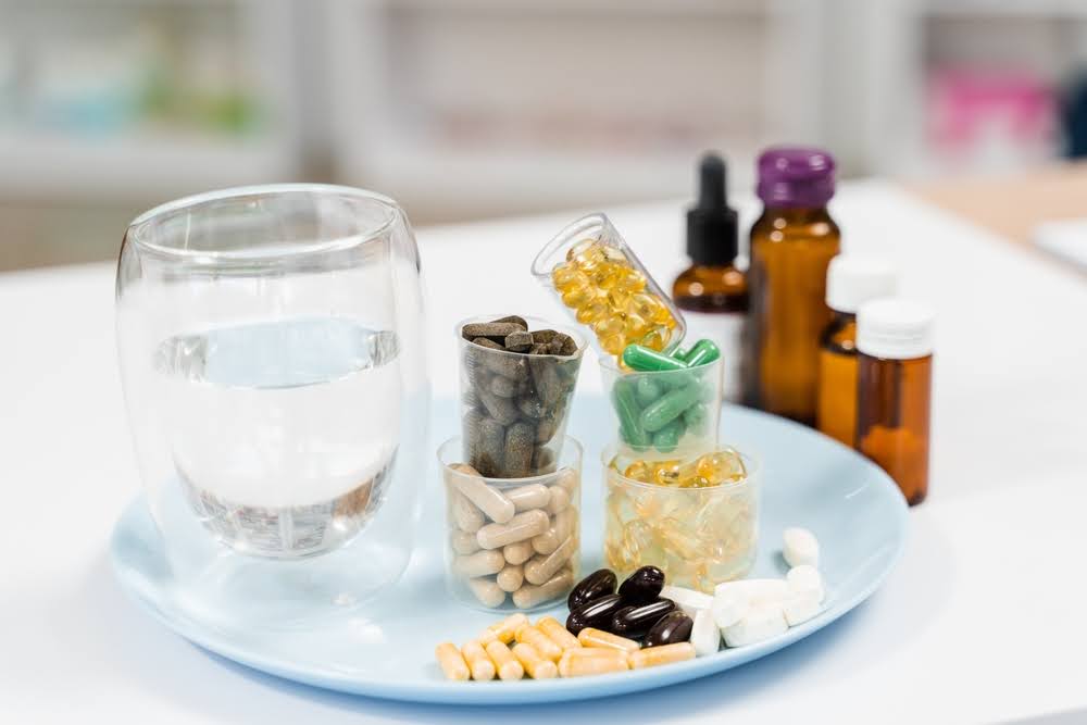 variety of adaptogen supplements in oil and capsule form on a counter