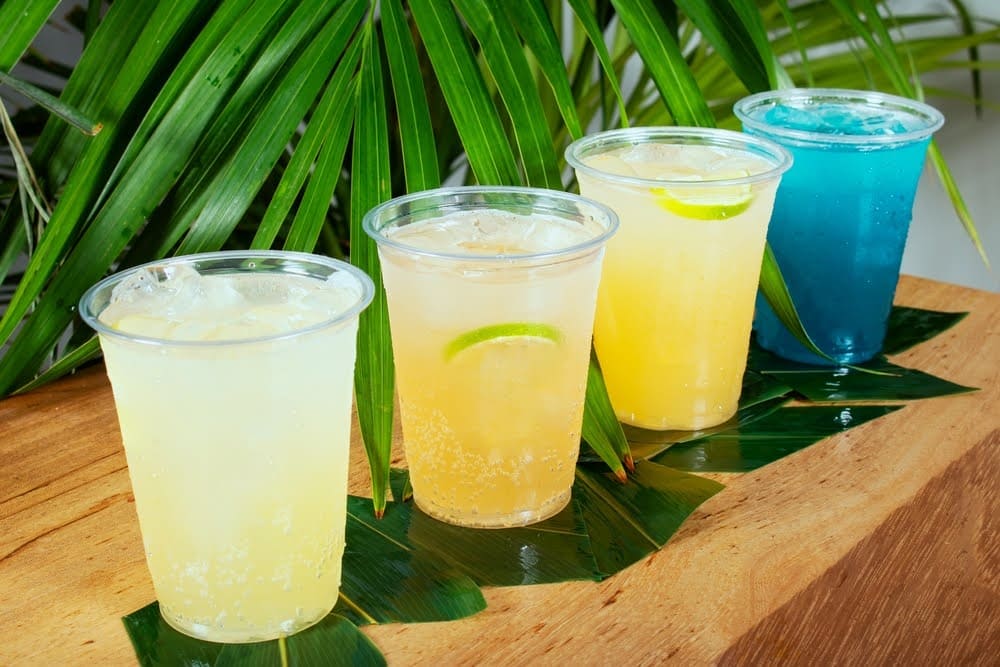 selection of different types of mocktails lined up on a wooden counter top