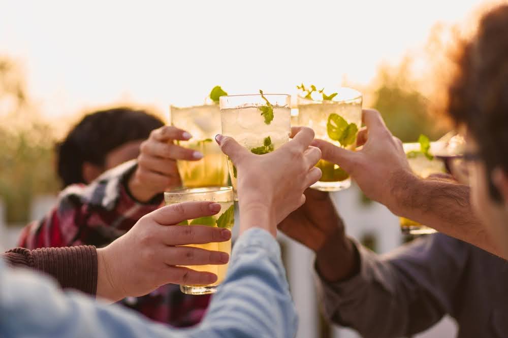 group of friends toasting with mocktail drinks