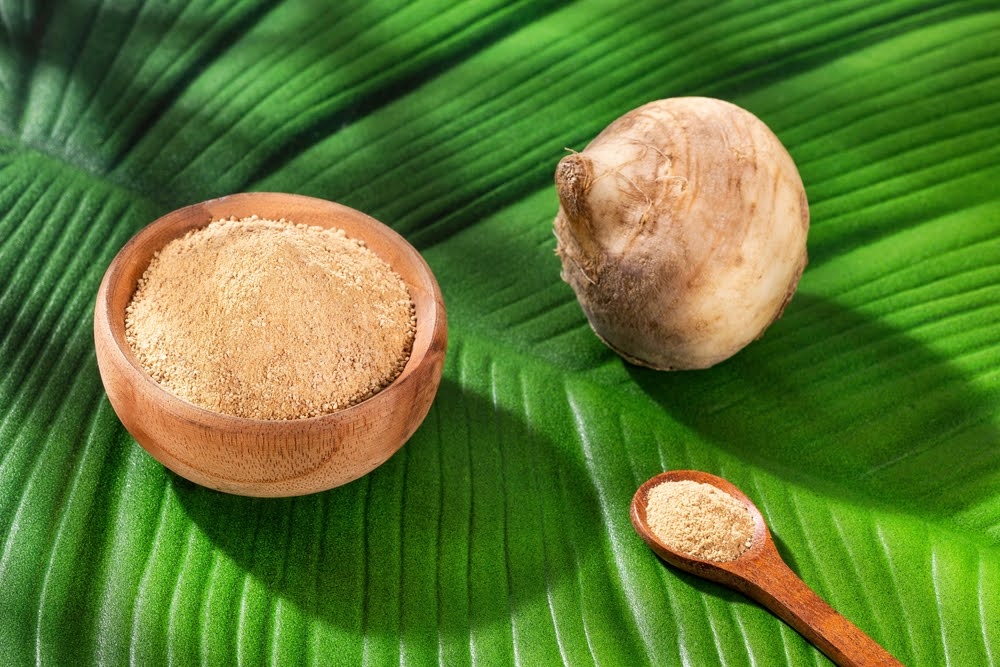 maca root and maca powder on a green leaf