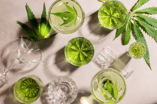 top-down image of glasses filled with water and surrounded by hemp leaves