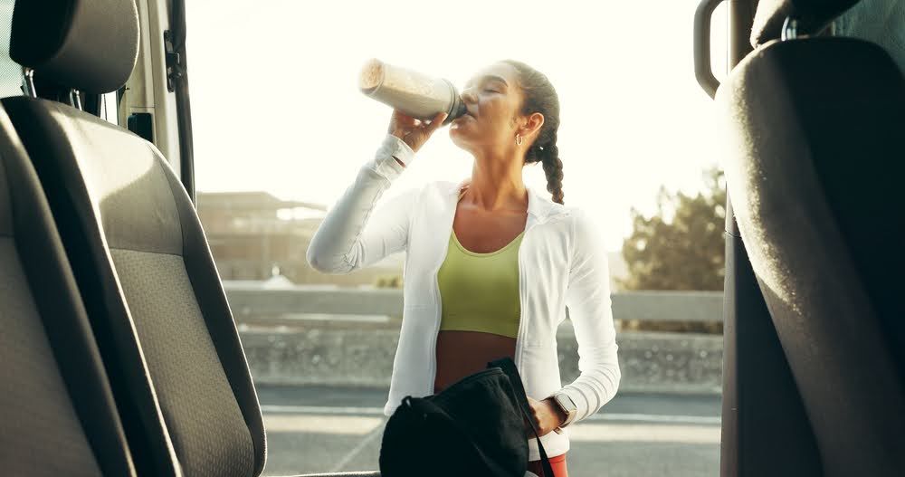 woman drinking a shake after a workout