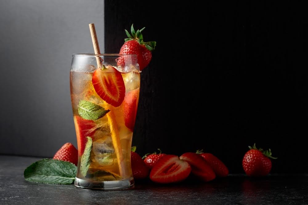 strawberry and mint infused thc drink in a glass against a dark background