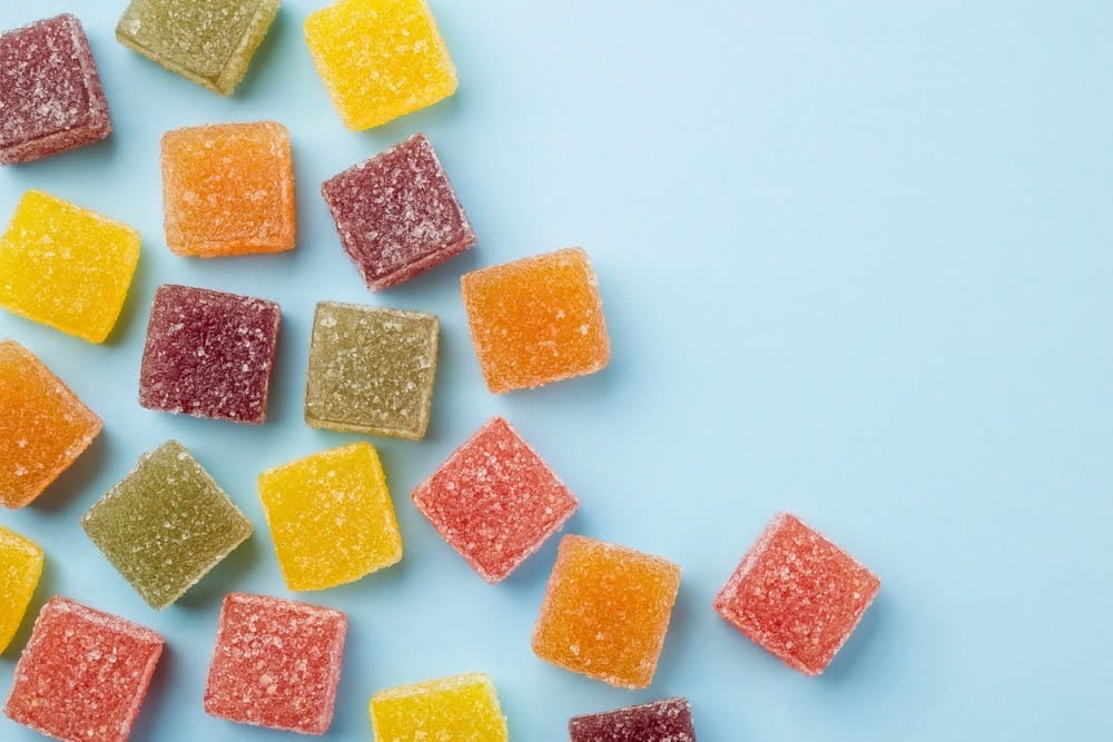selection of colorful gummies spread out on a light blue counter