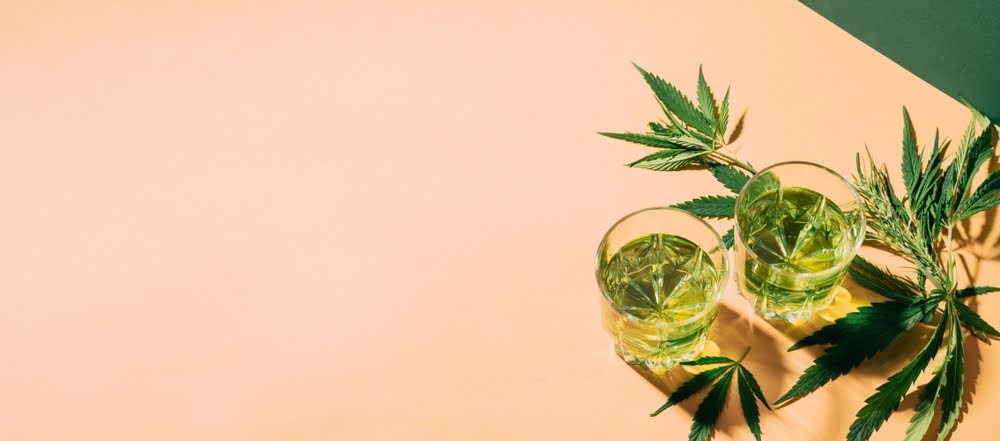 overhead shot of thc infused drinks on a peach colored counter