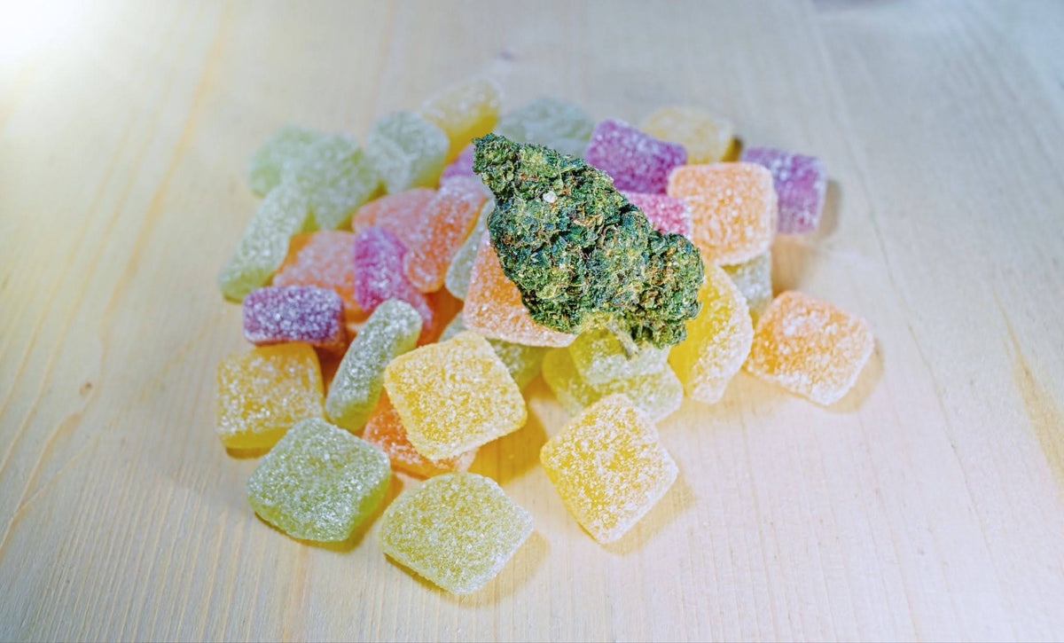 small pile of colorful THC gummies on a wooden countertop
